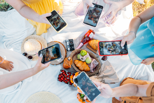 Social Media Content Ideas, Content creator for brands, food blog, summer picnic. Female hands, food blogger, content creator taking food photo via cell phone in picnic on nature background